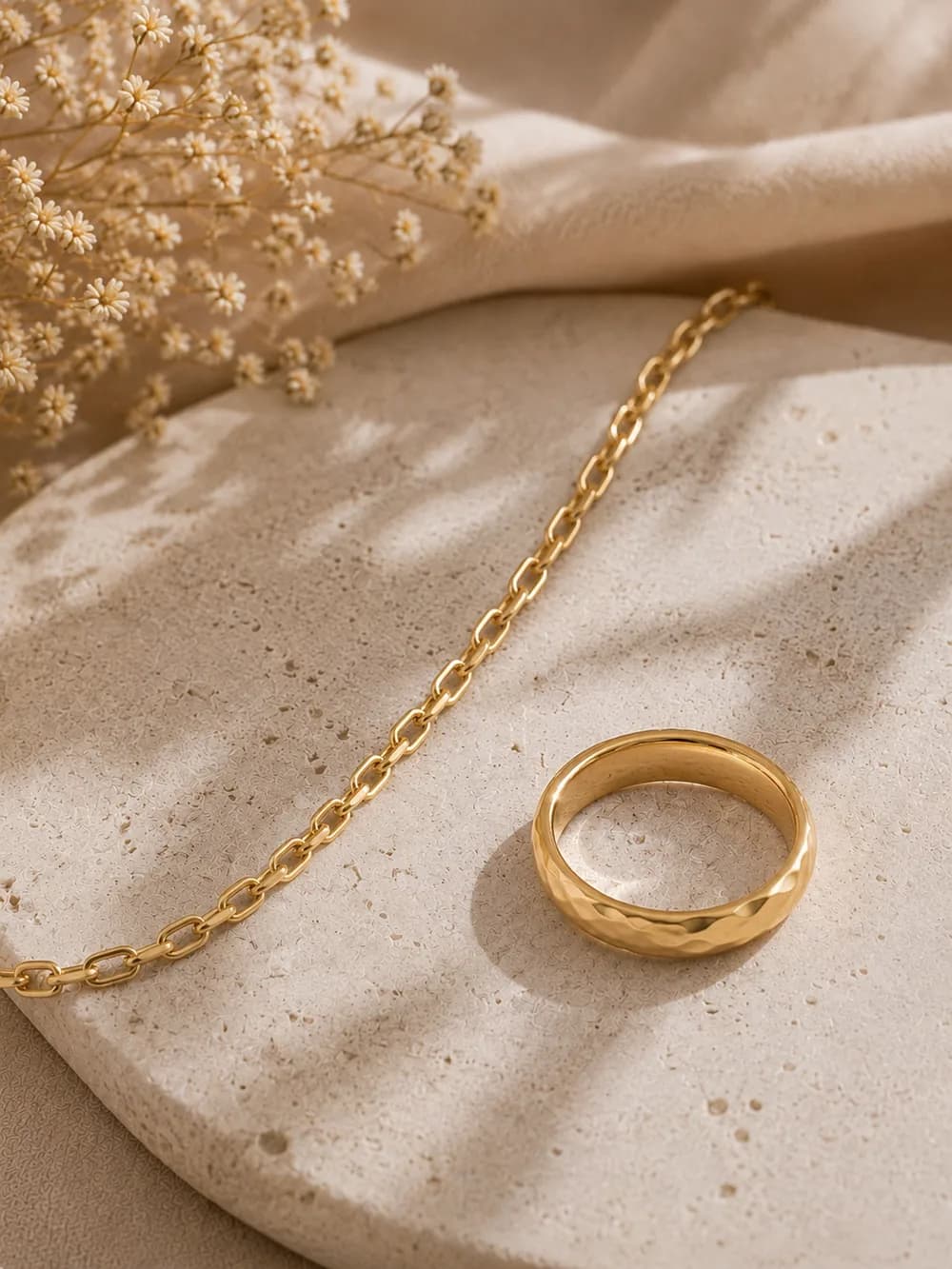 Anillo y cadena de oro laminado sobre piedra clara